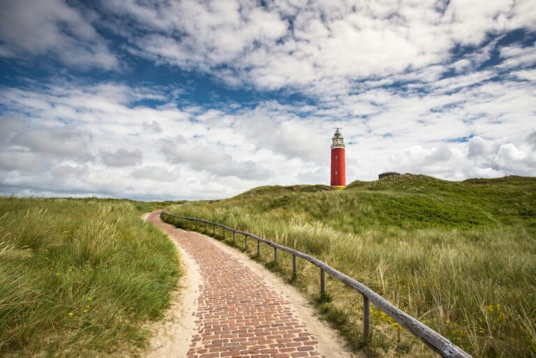 Promenades aux Pays-Bas et en Belgique. Promenade à Texel aux Pays-Bas, phare rouge, sentier pavé à travers les dunes.